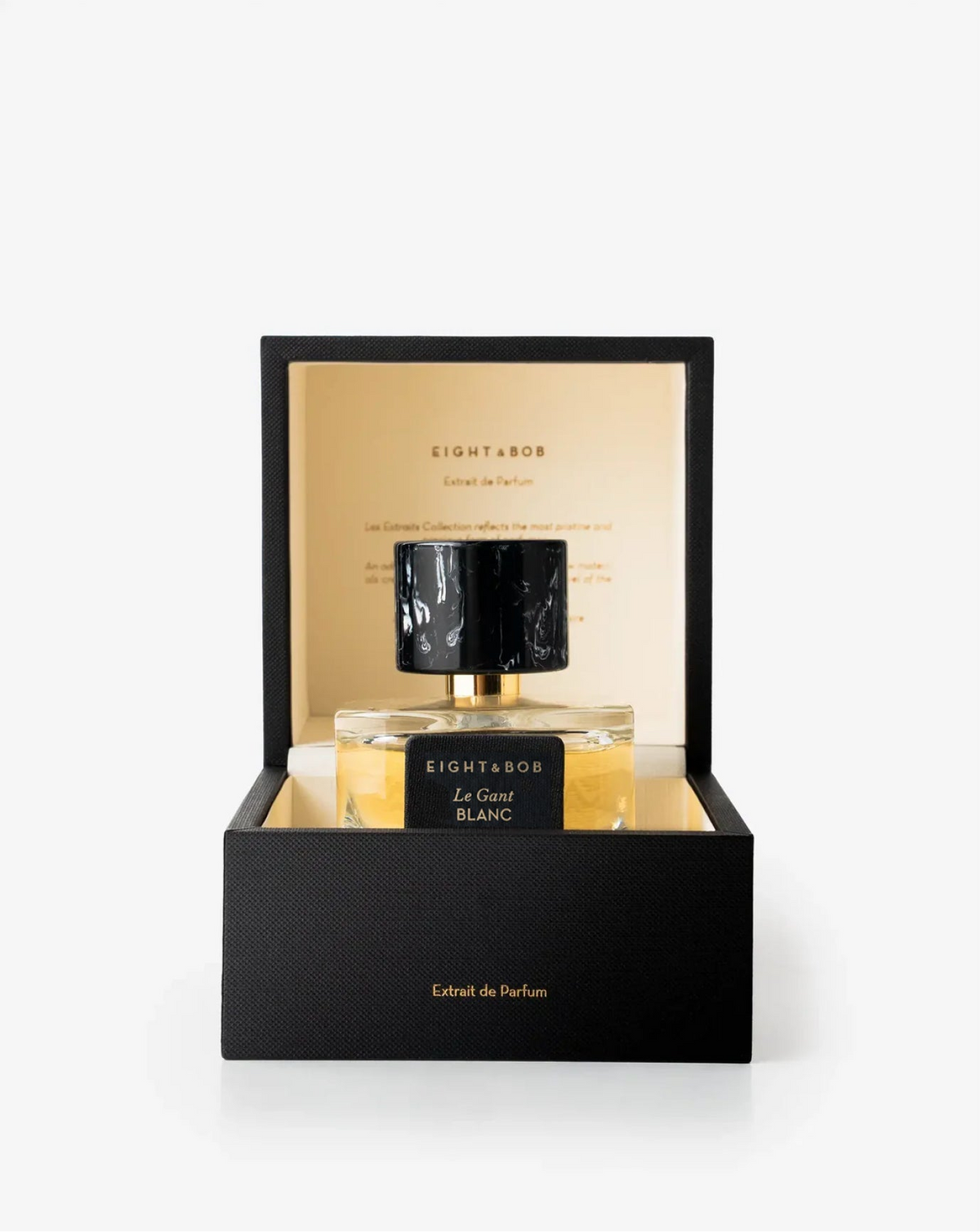 Eight & Bor Le Grand Blanc extrait de parfum in a black presentation box with a gold interior, featuring a clear glass bottle with a black marble-patterned cap.